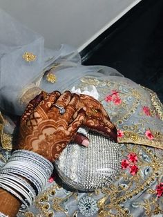 a close up of a person's hands with henna and jewelry on them