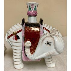 an elephant figurine with a red and white hat on it's head