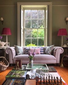 a living room filled with furniture next to a large window covered in lots of windows