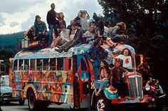 a group of people riding on the back of a colorful bus in front of other vehicles