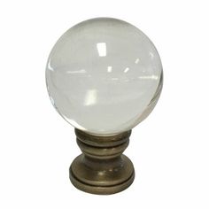 a clear glass ball on an antique brass base