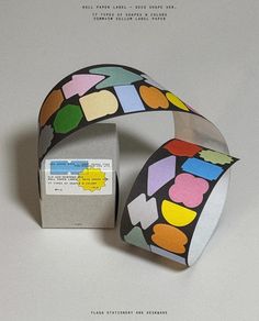 an image of a paper bracelet with colorful shapes on it and a card in front