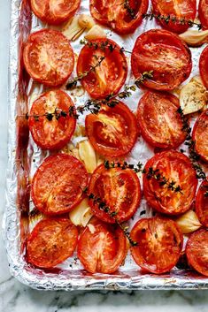 sliced tomatoes on a baking sheet ready to go into the oven for roasting and garnishing