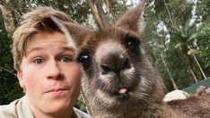 a man is posing with an animal in front of him