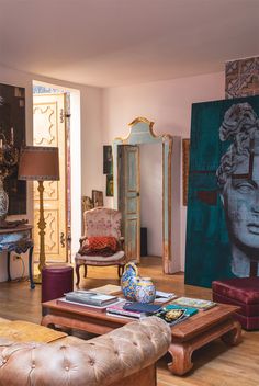 a living room filled with lots of furniture and paintings on the wall next to each other