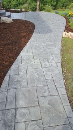 a stone walkway in the middle of a garden