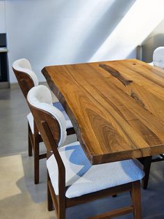 a wooden table with white chairs around it