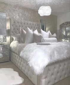 a bed with white fur on it in a bedroom next to a dresser and mirror