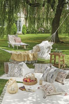 an outdoor hammock with pillows, blankets and other items laid out on the ground