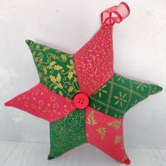 an ornament made out of fabric with a button in the middle and a star on top