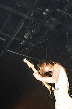 a man with long hair playing an electric guitar