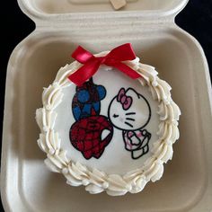 a cake in a box with a hello kitty decoration on it