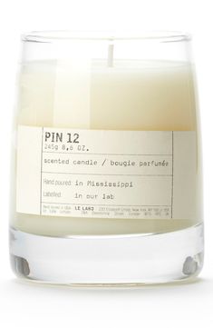 a candle that is inside of a glass jar with label on it, which reads laurier 6 2