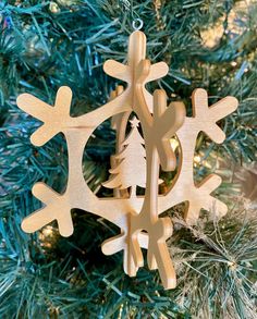 a wooden snowflake ornament hanging from a christmas tree