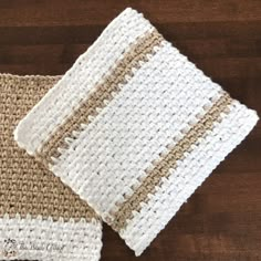 two crocheted dishcloths sitting on top of a wooden table