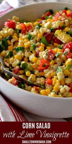 corn salad with lime vinaiette and tomatoes in a white bowl on a red and white tablecloth