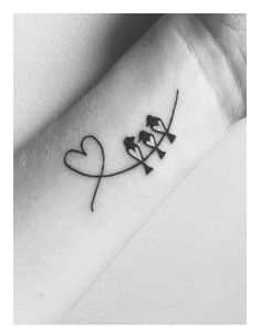 a black and white photo of a wrist tattoo with two birds on the side of it