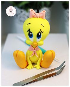 a yellow bird figurine sitting on top of a table next to a pair of scissors