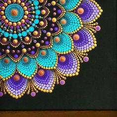 a painting with circles and dots in the center on a black background that looks like it has been made out of beads