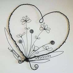 a wire heart with flowers attached to it