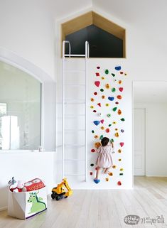 a child is climbing on the wall with toys