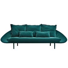 a green couch with four pillows on the back and one pillow on the side,