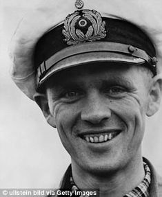 black and white photograph of a man in uniform smiling for the camera with his hat on