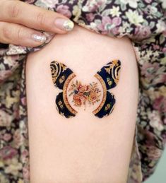 a woman's arm with an intricately decorated tattoo on her left side thigh