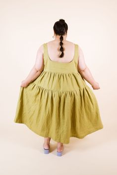 a woman with her back to the camera wearing a yellow dress