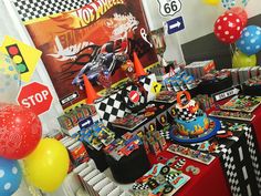 a birthday party with cars and balloons on the table at a race car themed birthday party