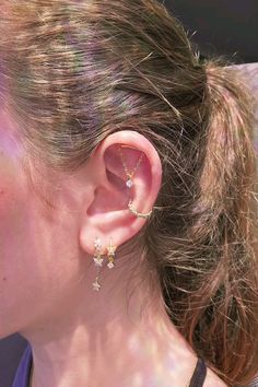 a close up of a person wearing some kind of earring with stars on it