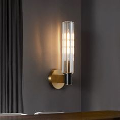 a modern light fixture mounted on the wall in a dining room or living room area