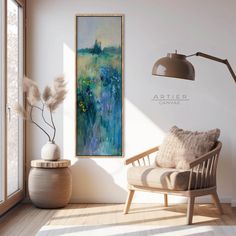 a painting hanging on the wall next to a chair and lamp in a living room