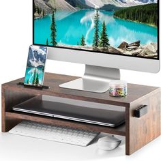 a computer monitor sitting on top of a wooden desk next to a keyboard and mouse