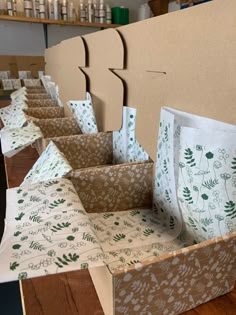 several boxes are lined up on the floor with green and white paper bags in them