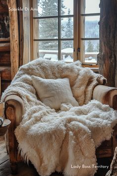 a chair with a blanket on top of it in front of a window that has snow outside