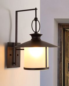 a light fixture mounted on the side of a wall next to a doorway and door