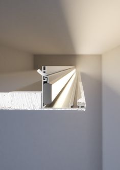 the corner of a room with white walls and a metal door handle on it's side