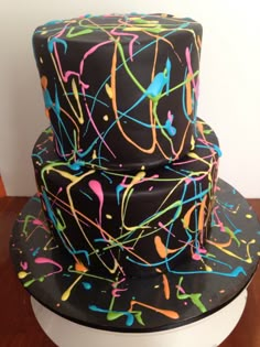 a three tiered cake decorated with multicolored icing