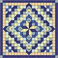 a blue and yellow quilt with an intricate design on the front, along with two rows of squares