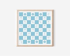 a blue and white checkerboard pattern with flowers on it, framed in a wooden frame