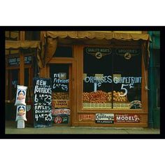 a store front with signs on it and oranges for sale in the foreground