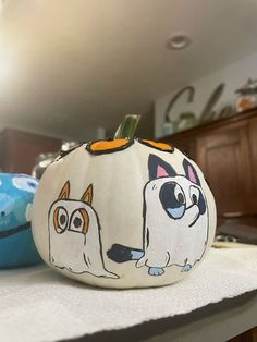 two painted pumpkins sitting on top of a kitchen counter