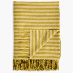 a yellow and white striped blanket with fringes