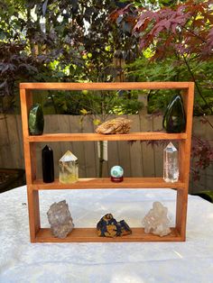 a wooden shelf filled with rocks and other items on top of a white table cloth