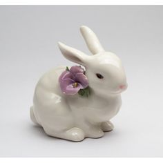 a white ceramic rabbit figurine with purple flowers