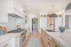 a kitchen with marble counter tops and wooden cabinets, along with an area rug on the floor