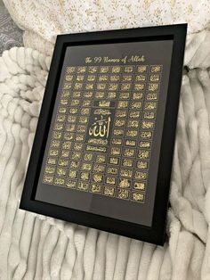 an arabic calligraphy framed in black and gold on a white blanket with the word'99 names of muslim written below it