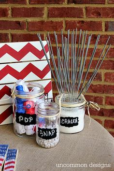 two jars filled with candles sitting on top of a table next to an american flag