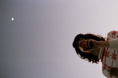 a man with his mouth open looking up at the moon in the sky behind him